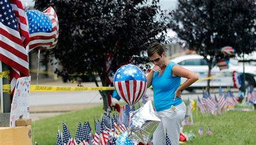 Regina Ingram looks at a makeshift memorial outside a military recruiting center Friday, where a gunman opened fire Thursday in Chattanooga.