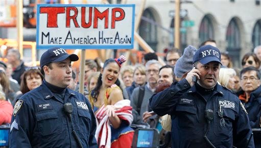 Police officers with the Counter Terrorism unit stand guard as activists protest against Republican presidential candidate Donald Trump outside The Plaza Hotel, where Trump is attending the Pennsylvania Republican party's annual Commonwealth Club luncheon, Friday, Dec. 11, 2015, in New York.