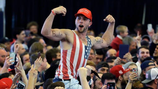 FILE - In this April 15, 2016, file photo, a Donald Trump supporter flexes his muscles with the words "Build The Wall" written on them as Trump speaks at a campaign rally in Plattsburgh, N.Y. Congressional Republicans and Donald Trump's transition team are exploring whether they can make good on Trump's promise of a wall on the U.S.-Mexico border without passing a new bill on the topic, officials said Thursday, Jan. 5. (AP Photo/Elise Amendola, File)