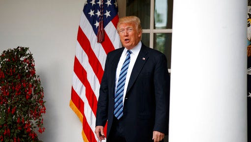 President Donald Trump talks with reporters as he walks to the Oval Office of the White House in Washington on May 2.