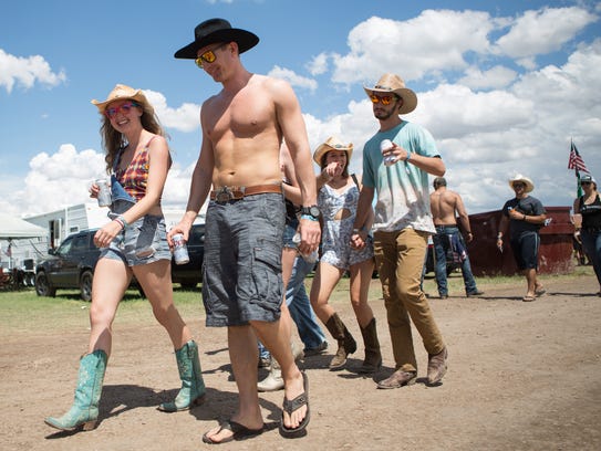Festival-goers walk through campgrounds during Day