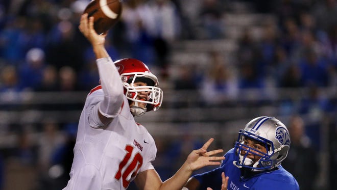 HSE Royals linebacker Collin Miller pressures Fishers Tigers quarterback Zach Eaton as he passes deep in Hamilton Southeastern territory in the fourth quarter, en route to the Tigers' 41-10 win over the Royals at HSE on Friday, September 12, 2014.