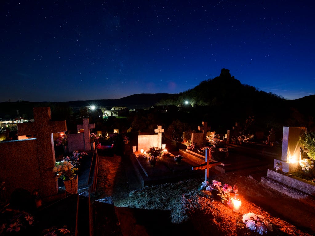Candles illuminate graves ahead of All Saints' Day in the cemetery of the village of Hajnacka, Slovakia.