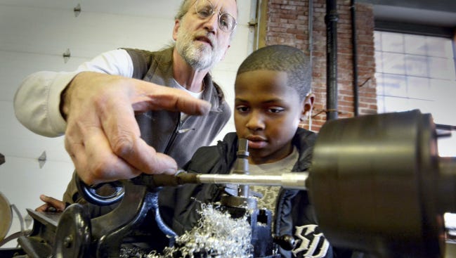 Dennis Kunkle, left, of the York County Heritage Trust, shows Steve Roland, 10, how metal workers used old lathes at the Agricultural and Industrial Museum in 2015.