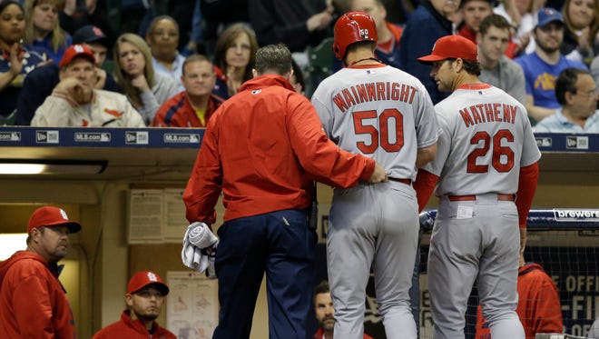 St. Louis Cardinals starting pitcher Adam Wainwright (50) is helped off the field after getting injured while batting during the fourth inning of a baseball game against the Milwaukee Brewers Saturday, April 25, 2015, in Milwaukee.