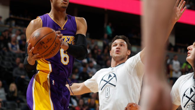 Los Angeles Lakers guard Jordan Clarkson, left, drives to the net as Denver Nuggets forward Danilo Gallinari, of Italy, defends in the first half of an NBA basketball game Monday, March 13, 2017, in Denver. (AP Photo/David Zalubowski)