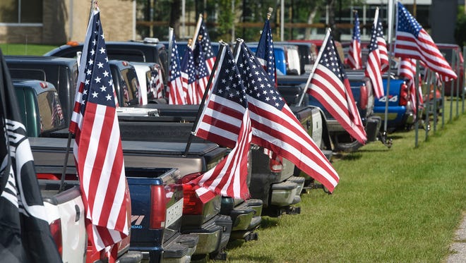 Dozens of American flags fly from a row of student vehicles Wednesday, Sept. 6, in the parking lot of Rocori High School in Cold Spring. 