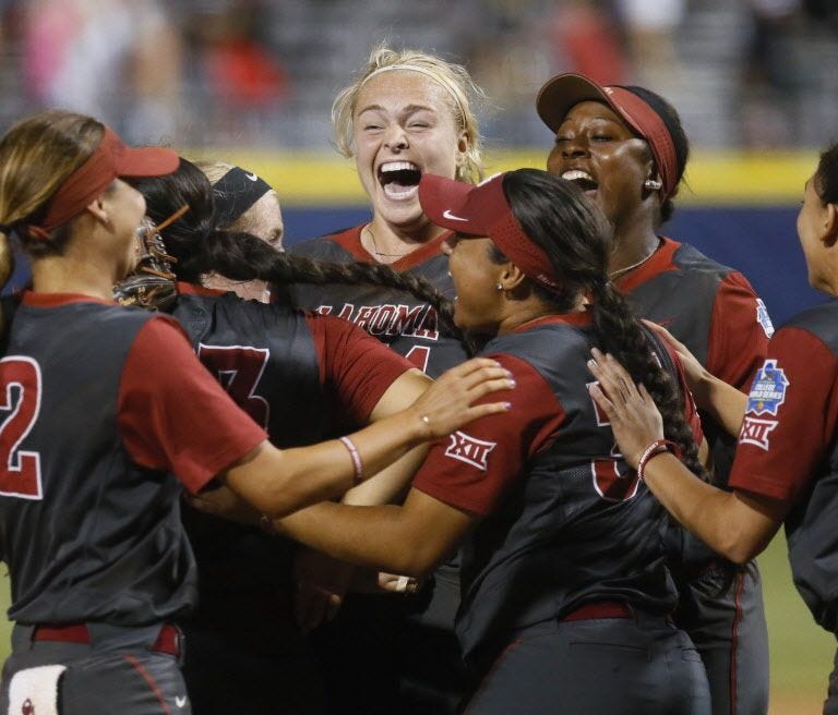 Oklahoma starting pitcher Paige Lowary, rear center, celebrates with teammates after Oklahoma defeated Florida in the first game of the best-of-three championship series in the Women's College World Series.