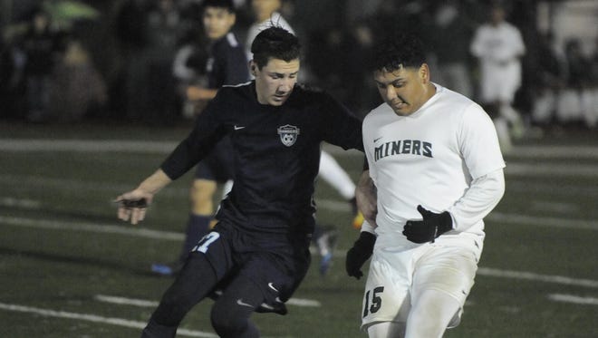 El Diamante Tyler Esteves and Redwood's Logan Corley battle for the ball in Friday’s Central Section Division II quarterfinal match at College of the Sequoias.