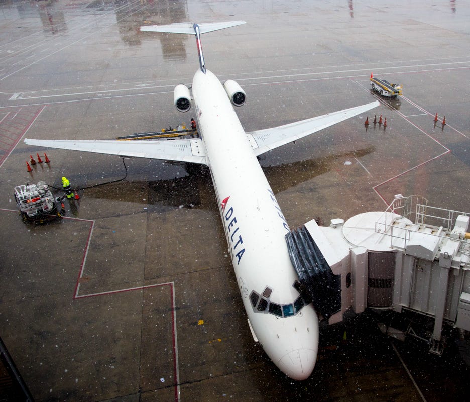 A Delta Air Lines MD-88 gathers snow at the beginning of a winter storm at Atlanta-Hartsfield International Airport on Dec. 8, 2017.