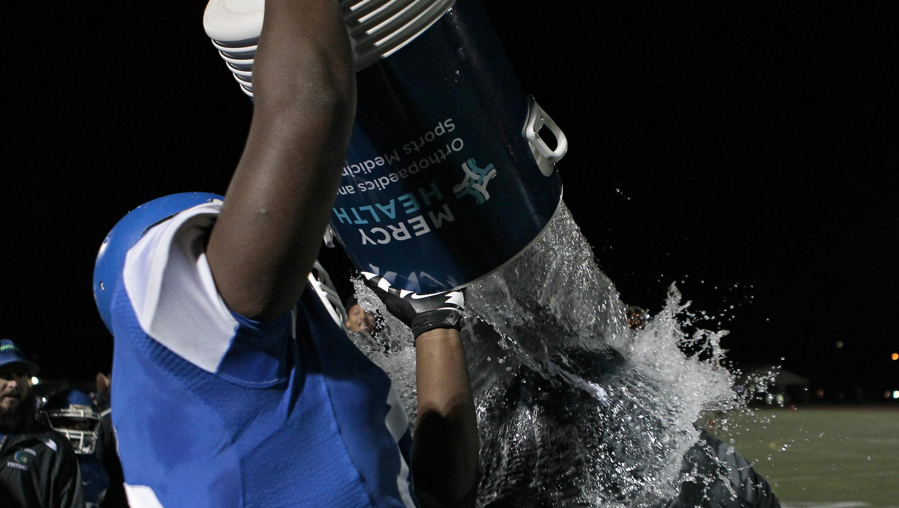 Winton Woods junior Jerron Cage soaks head coach Andre Parker as time expires in the fourth quarter of the Warriors' win over Elder
