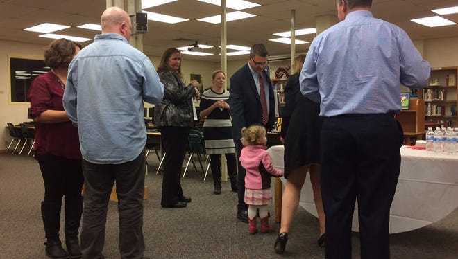 T.J. Walker Middle School candidate  Mark Smullen (center) gets his daughter Abby a cookie before the start of the principal candidate meet-and-greet Wednesday afternoon.