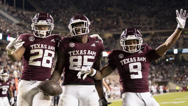 Texas A&M tight end Jalen Wydermyer is flanked by jubilant teammates Isaiah Spiller, left, and Hezekiah Jones after a touchdown catch against Arkansas in Saturday's 42-31 win at Kyle Field. Wydermyer caught two touchdown passes in the win.