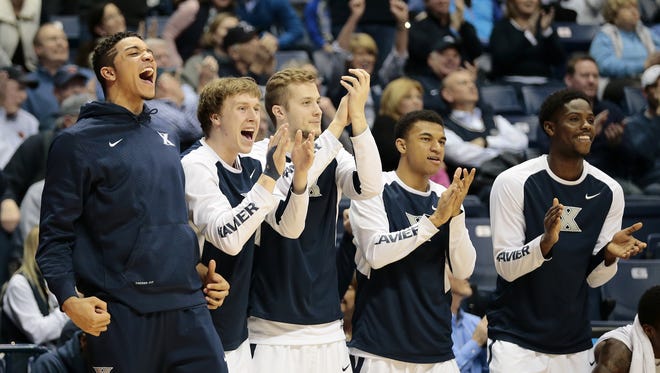 The Xavier Musketeers bench cheers as guard Myles Davis (15) tallies a triple double.