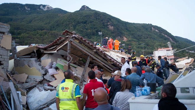 Italian firemen and emergency workers search through rubble of a collapsed house in Ischia, on Aug. 22, 2017, after an earthquake hit the popular Italian tourist island off the coast of Naples, causing several buildings to collapse overnight.