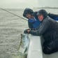 Inshore guide Glyn Austin of Palm Bay, right, holds the tarpon for the picture and angler Mark Hanley of Rockledge eyes his catch before it was released beside the boat in a rain storm.