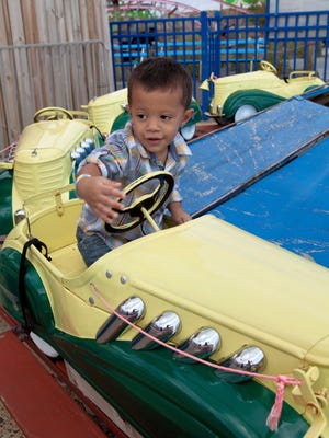 A boy rides the vintage kiddie pedal cars at the Keansburg Amusement Park. The ride turns 80 this season.