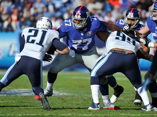 Former Ole Miss offensive lineman John Jerry (77) blocks two members of the Tennessee Titans during their game in 2014.