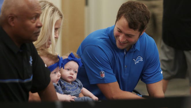 Detroit Lions quarterback Matthew Stafford sits with his wife Kelly B. Stafford and their twins Sawyer and Chandler Stafford before a press conference about his $135 million five-year contract extension at the Detroit Lions Training Camp in Allen Park on Tuesday August 29, 2017.
