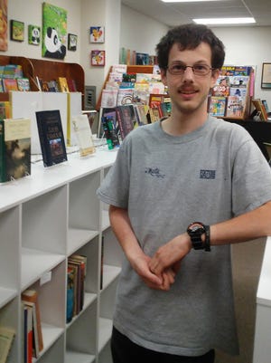 Store employee Kevin Gossen poses inside Other Worlds Books & More in Sturgeon Bay.
