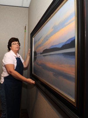 
In this 2011 file photo, curator Jane Weinke hangs up artworks for the annual “Birds in Art” exhibit at the Woodson Art Museum in Wausau. 
