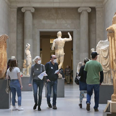 Two visitors wear masks as they walk through the M