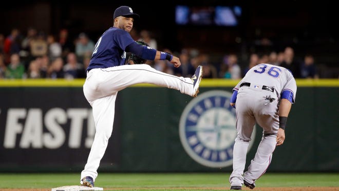 Seattle Mariners second baseman Robinson Cano, left, watches his throw to first base after forcing out Texas Rangers' Carlos Beltran at second base in the sixth inning of a baseball game Tuesday, Sept. 6, 2016, in Seattle. Adrian Beltre was safe at first.