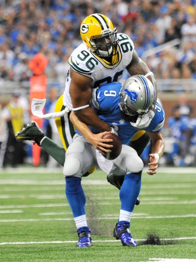 Packers' Mike Neal tackles Lions quarterback Matthew Stafford on a third down attempt in the second quarter.