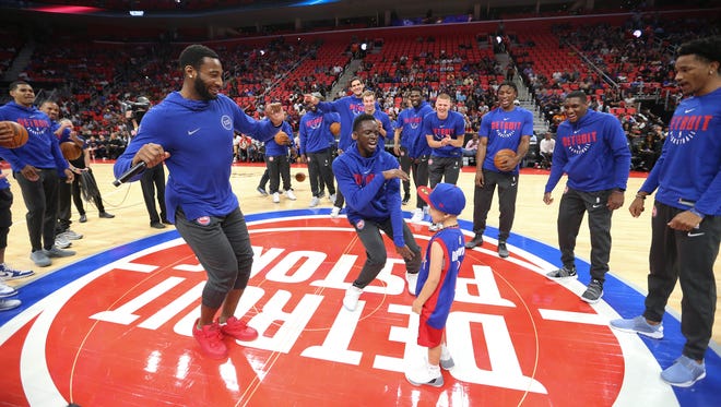 Pistons center Andre Drummond and guard Reggie Jackson dance with Zack Jaafar from Dearborn Heights during the Meet the Team event at Little Caesars Arena on Tuesday, Oct. 3, 2017.