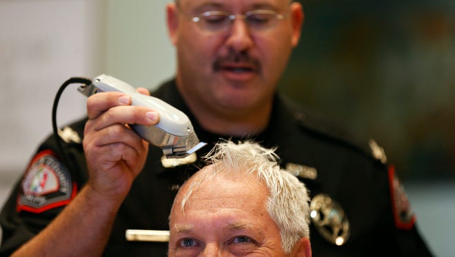Greene County presiding commissioner Bob Cirtin got his head shaved by Greene County Sheriff Jim Arnott in the rotunda of the Historic Greene County Courthouse in Springfield, Mo. on Oct. 14, 2015. Cirtin challenged county employees to double their participation with United Way compared to the past year, and in reward he would let Sheriff Arnott shave off his hair.
