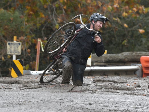 Carpinteria resident Jeff Gallup carries his bike through