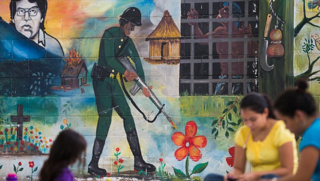 A mural on a wall at a pre-school in San Salvador, El Salvador greet kids and teachers June 19, 2014. The soldier shooting flowers represents the destruction caused by civil war.