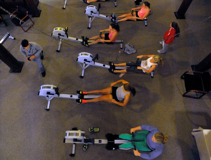 Members of the Detroit Boat Club Crew practice on ergometers in the main floor lobby of the Belle Isle boathouse.. The rowing club is working out a deal with the state to lease the boathouse.