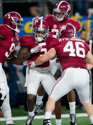 Alabama defensive back Cyrus Jones (5) celebrates with teammates defensive lineman Da’Shawn Hand (9), defensive back Anthony Averett (28) and tight end Michael Nysewander (46) during second half action in the Cotton Bowl on Thursday December 31, 2015 at AT&T Stadium in Arlington, Tx. (Mickey Welsh / Montgomery Advertiser)