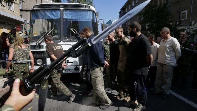 Pro-Russia rebels escort captured Ukrainian army prisoners in a central square in Donetsk, eastern Ukraine, Aug. 24, 2014.