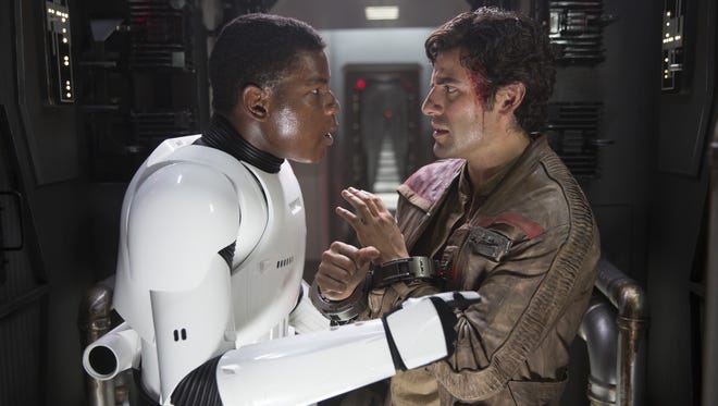 Finn (John Boyega, left) runs into Poe Dameron (Oscar Isaac) aboard a First Order ship in 'Star Wars: The Force Awakens.'