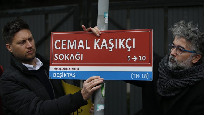 Members of Amnesty International place an unofficial street sign reading in Turkish: 'Jamal Khashoggi Street,' near the Saudi consulate in Istanbul, Jan. 10, 2019, marking the 100th day since Saudi journalist Jamal Khashoggi was killed in the kingdom's consulate on Oct. 2.