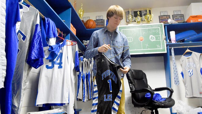 Student manager Dylan Wimer of the varsity boys basketball team gathers together the team's jerseys from the locker room to wash them at Robert E. Lee High School on Friday, Jan. 29, 2016.  The task is just one of several he does to assist the team. 