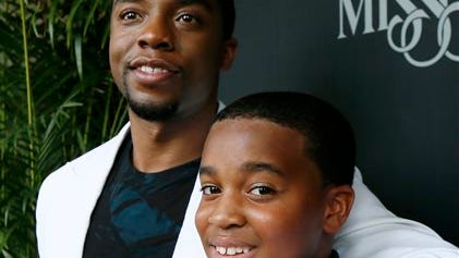 Chadwick Boseman, who stars as James Brown in "Get On Up," a movie based on the life story of "the Godfather of Soul," hugs Alvin Edney, 14, who played Brown's son Teddy, prior to a screening of the film Sunday in Madison. The film, directed by Mississippi native Tate Taylor, depicts Brown's life from 5-years-old until he was 60. Brown died in 2006 at 73.