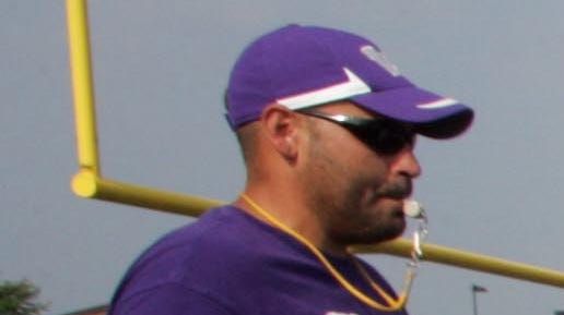 Tim Eischen, left, in hat, is shown in a 2011 at a football camp held at Waukee.