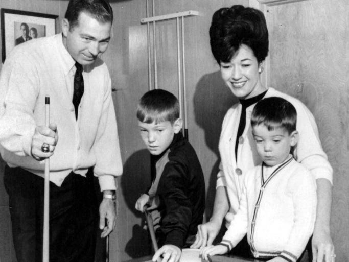 Green Bay Packers quarterback Bart Starr watches his son Bart Jr., 9, line up a shot at the pool table in their Green Bay home in 1966. Starr's wife Cherry and their other son, Bret, 2, look on.