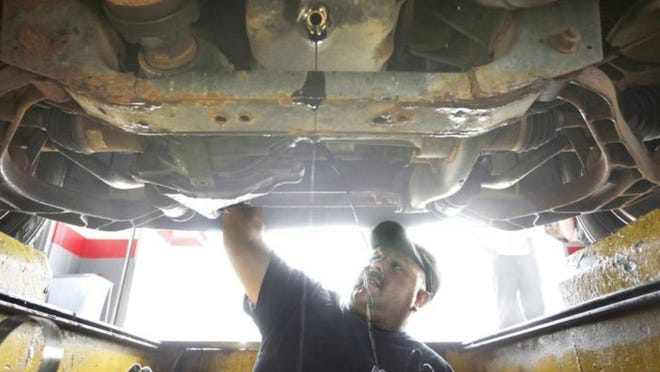 Dennis Aikey of Naples changes the oil on an SUV at Power Automotive in Canandaigua.
