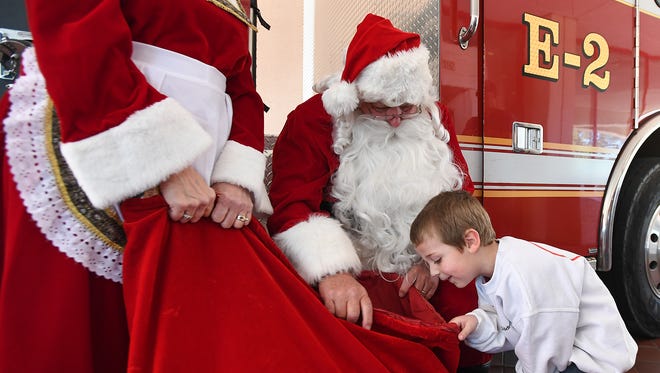 Three-year-old Jon Cousino gets a peek in Santa's bag at the Greenville Shriners Hospital on Thursday, December 15, 2016. Santa and Mrs. Clause were at the hospital to give out toys that were collected during a Christmas toy drive for patients.