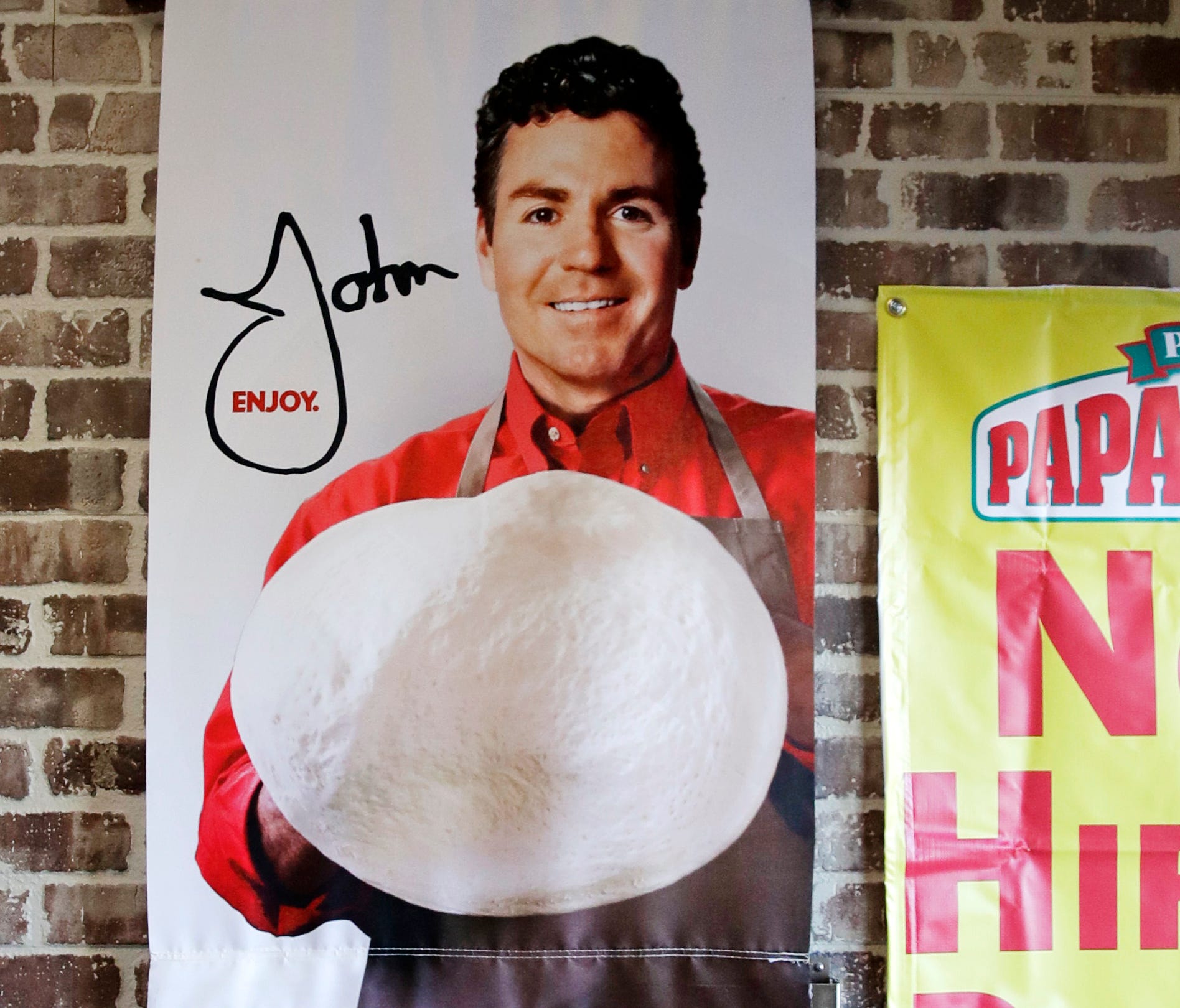 Signs, including one featuring Papa John's founder John Schnatter, at a Papa John's pizza store in Quincy, Mass. Papa John's plans to pull Schnatter's image from marketing materials after reports he used a racial slur. Schnatter apologized Wednesday,