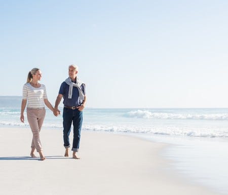Middle-aged couple walking along the beach