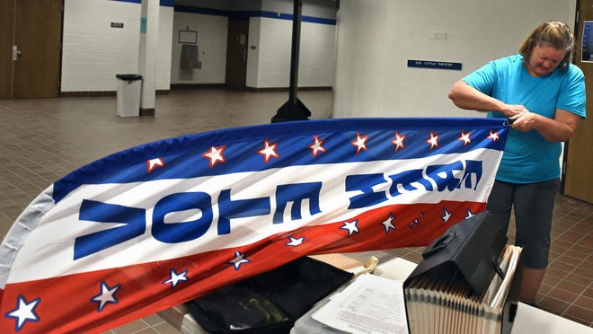 Volunteer Linda Justus gets a flag ready for the Nevada primary at McQueen High School in June 2016.
