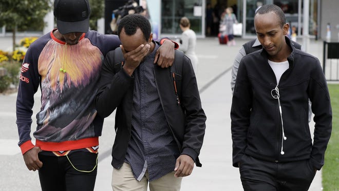 Abdifatah Ibrahim, center, and his brother Abdi, right, walk with an unidentified friend in Christchurch, New Zealand, Sunday, March 17, 2019. Abdifatah and Abdi are the older brothers of three-year-old Mucaad, who is the youngest known victim of the mass shooting in Christchurch, New Zealand on Friday, March 15.