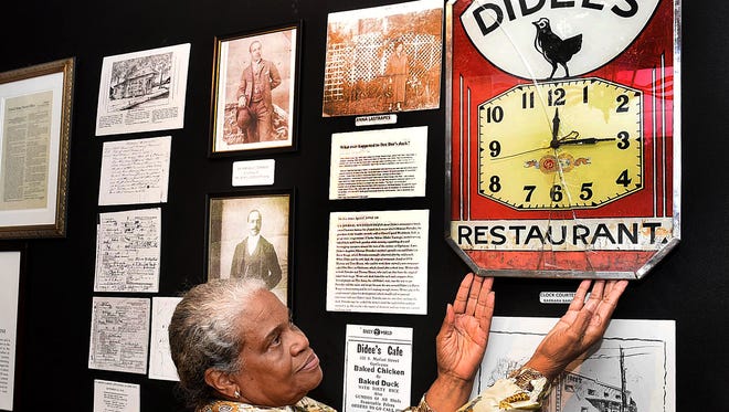 Marie Marcel displays a clock from Didee's Restaurant, part of a Black History Month exhibit at the Opelousas Museum and Interpretive Center.