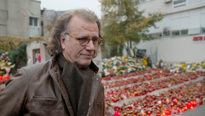 Dutch violinist and conductor Andre Rieu leaves after laying flowers outside the Colectiv nightclub in Bucharest, Romania, Saturday, Nov. 7, 2015. Seven more people have died a week after a fire broke out in a Bucharest nightclub. Romanian authorities said Saturday, about 100 other people still remain hospitalized, of which 48 are in a serious or critical condition, from the Oct. 30 blaze that erupted at the Colectiv nightclub during a heavy-metal concert. (AP Photo/Vadim Ghirda)