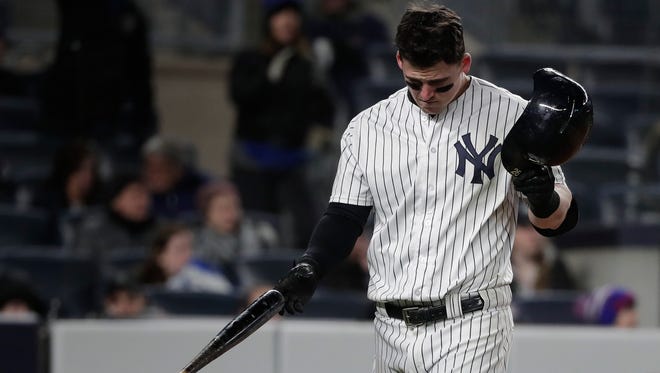 New York Yankees' Tyler Austin pulls off his batting helmet after striking out against the Toronto Blue Jays to end the eighth inning of a baseball game, Friday, April 20, 2018, in New York.